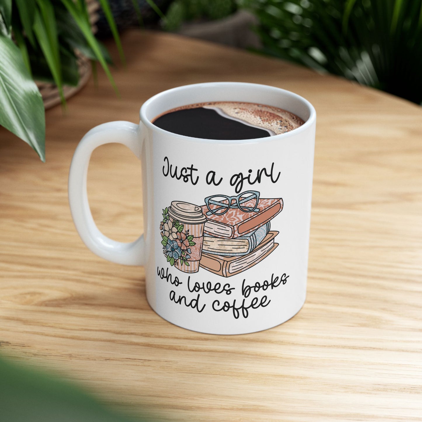 Cozy Book Lover mug next to a book and blanket on a coffee table