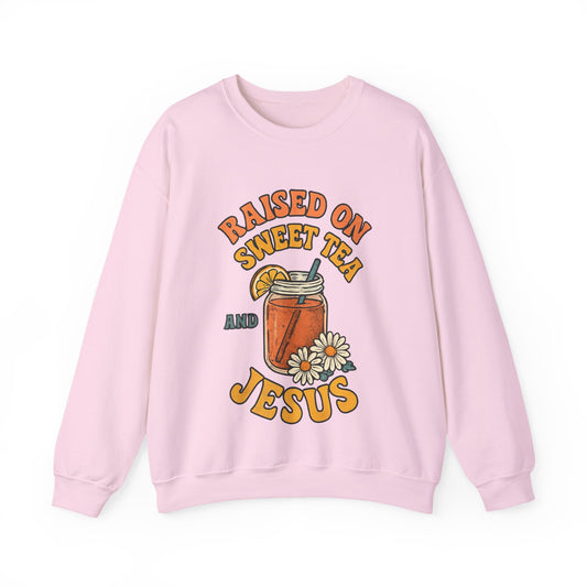 Flat lay of Southern Charm crewneck sweatshirt with 'Raised on Sweet Tea & Jesus' graphic on light background